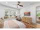 Bright bedroom features a cozy window seat, TV, and dresser with a modern ceiling fan at 1341 Place Picardy, Winter Park, FL 32789
