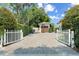 Long paved driveway is gated with a basketball hoop on the garage at 1341 Place Picardy, Winter Park, FL 32789