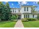 Beautiful two-story home with manicured lawn, lush landscaping, and a welcoming brick walkway at 1341 Place Picardy, Winter Park, FL 32789