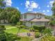 Two-story home exterior has mature landscaping and a swing set in the yard at 1341 Place Picardy, Winter Park, FL 32789