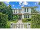 Beautiful two-story white home with a manicured lawn, a garden, and a charming white picket fence at 1341 Place Picardy, Winter Park, FL 32789
