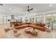 Open-concept living space with a large sectional couch, ceiling fan and modern kitchen at 1341 Place Picardy, Winter Park, FL 32789