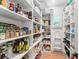 Organized walk-in pantry features white shelving, natural wood flooring, and a ladder for accessing top shelves at 1341 Place Picardy, Winter Park, FL 32789