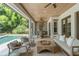 Relaxing covered patio area features comfortable seating, ceiling fans, an outdoor kitchen, and a view of the pool at 1341 Place Picardy, Winter Park, FL 32789