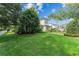 Expansive green lawn on the side of this home, framed by mature trees, offering a serene outdoor space at 1341 Place Picardy, Winter Park, FL 32789