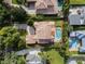Aerial view of a home with a pool, lush landscaping, and a terracotta tile roof at 1394 Grove Ter, Winter Park, FL 32789
