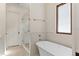 Bathroom with a modern tub, glass-enclosed shower, tiled walls, and a white door at 1394 Grove Ter, Winter Park, FL 32789