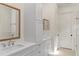 Bathroom with double vanity sinks, framed mirrors, white cabinets and a walk-in glass shower at 1394 Grove Ter, Winter Park, FL 32789