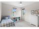 Bright bedroom featuring a blue and white bed, shelving, and light-filled windows at 1394 Grove Ter, Winter Park, FL 32789