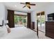 Comfortable bedroom with pool access, ceiling fan, neutral tones, and large windows at 1394 Grove Ter, Winter Park, FL 32789