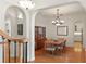Inviting dining room featuring hardwood floors, a classic chandelier, and an arched doorway to the kitchen at 1394 Grove Ter, Winter Park, FL 32789
