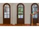 Light and airy entryway features striking brown arched doors, sidelights, and wood floors at 1394 Grove Ter, Winter Park, FL 32789
