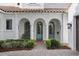 Home entrance showcases turquoise doors framed by arched entryways, columns, and a brick walkway at 1394 Grove Ter, Winter Park, FL 32789