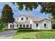 Stunning two-story home features a beautiful lawn, clay tile roof, and white stucco exterior at 1394 Grove Ter, Winter Park, FL 32789