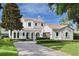 Two-story home with white stucco and a clay tile roof, complemented by a manicured lawn and brick driveway at 1394 Grove Ter, Winter Park, FL 32789