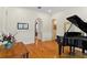 Elegant living room with a grand piano, archways, and hardwood floors at 1394 Grove Ter, Winter Park, FL 32789