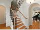 Staircase with hardwood steps, wrought iron spindles, and a view of the piano room at 1394 Grove Ter, Winter Park, FL 32789