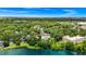 Stunning aerial view of the property in a lush, green neighborhood along the serene lake at 1420 Rock Lake Dr, Orlando, FL 32805