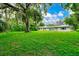 Expansive backyard featuring mature trees, lush green grass, and the back of the home at 1420 Rock Lake Dr, Orlando, FL 32805