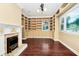 Inviting living room featuring custom built-in shelving, fireplace, dark wood floors and natural light at 1420 Rock Lake Dr, Orlando, FL 32805