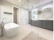 Modern bathroom featuring a standalone tub, glass-enclosed shower, and gray vanity with double sinks at 16210 Ravenna Ct, Montverde, FL 34756