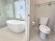 Bright bathroom featuring a freestanding soaking tub with modern fixtures next to the toilet at 16210 Ravenna Ct, Montverde, FL 34756