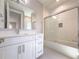 Bright bathroom features a white vanity, large mirror, and shower-tub with sliding glass door at 16210 Ravenna Ct, Montverde, FL 34756