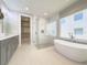 Luxurious bathroom with a soaking tub, glass shower, double vanity, and walk-in closet for ample storage at 16210 Ravenna Ct, Montverde, FL 34756