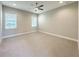 Spacious bedroom with neutral carpet, ceiling fan, and natural light streaming through the windows at 16210 Ravenna Ct, Montverde, FL 34756
