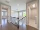 Open hallway boasts a staircase with decorative hanging lights and a convenient, nearby laundry room at 16210 Ravenna Ct, Montverde, FL 34756