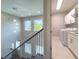 Open hallway boasts a staircase with decorative hanging lights and a nearby laundry room at 16210 Ravenna Ct, Montverde, FL 34756