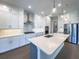 Bright kitchen features white cabinets, stainless steel appliances, and a center island with pendant lighting at 16210 Ravenna Ct, Montverde, FL 34756