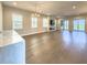 Spacious living room with hardwood floors, a modern fireplace, a ceiling fan, and plenty of light at 16210 Ravenna Ct, Montverde, FL 34756