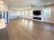 Open-concept living room boasts hardwood floors, large windows, and a decorative fireplace with a mounted television at 16210 Ravenna Ct, Montverde, FL 34756