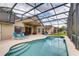 Spacious backyard featuring a pristine swimming pool, patio, and screened enclosure at 1956 Southern Dunes Blvd, Haines City, FL 33844