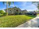 Inviting home exterior featuring a well-manicured lawn, mature trees, and charming architectural details at 1956 Southern Dunes Blvd, Haines City, FL 33844