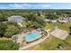 Aerial view of a community featuring a pool area, clubhouse, and surrounding lush landscaping, and nearby residences at 25105 Laurel Valley Rd, Leesburg, FL 34748
