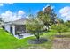 Landscaped backyard featuring lush lawn, mature trees, and a screened lanai at 25105 Laurel Valley Rd, Leesburg, FL 34748