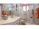 Bathroom with a glass shower, marble countertops, and orange decorative towels at 25105 Laurel Valley Rd, Leesburg, FL 34748