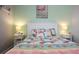 Bedroom featuring flamingo-themed decor and a queen bed with two side tables at 25105 Laurel Valley Rd, Leesburg, FL 34748