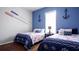 Nautical-themed bedroom with two twin beds and decorative anchors on a blue wall at 25105 Laurel Valley Rd, Leesburg, FL 34748