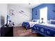 Charming nautical-themed bedroom with two twin beds, TV and wood-look floors at 25105 Laurel Valley Rd, Leesburg, FL 34748