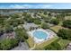Aerial view of the large community pool with ample seating, tennis courts, and surrounding green spaces for relaxation and recreation at 25105 Laurel Valley Rd, Leesburg, FL 34748