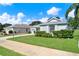 Landscaped lawn complements this home with a brick driveway and tasteful shrubbery at 25105 Laurel Valley Rd, Leesburg, FL 34748