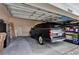Spacious garage with a car, storage shelves, and a refrigerator at 25105 Laurel Valley Rd, Leesburg, FL 34748