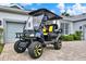 Custom black and yellow golf cart parked in front of a well-maintained home at 25105 Laurel Valley Rd, Leesburg, FL 34748