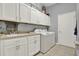 Spacious laundry room with white cabinets, sink, and washer/dryer at 25105 Laurel Valley Rd, Leesburg, FL 34748