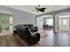 Open-concept living area with hardwood floors, archways, and comfortable leather seating at 25105 Laurel Valley Rd, Leesburg, FL 34748