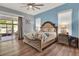Comfortable main bedroom with wood floors, en-suite access, and large windows at 25105 Laurel Valley Rd, Leesburg, FL 34748