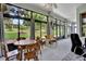 Bright sunroom with large windows overlooking the yard and a ceiling fan at 25105 Laurel Valley Rd, Leesburg, FL 34748